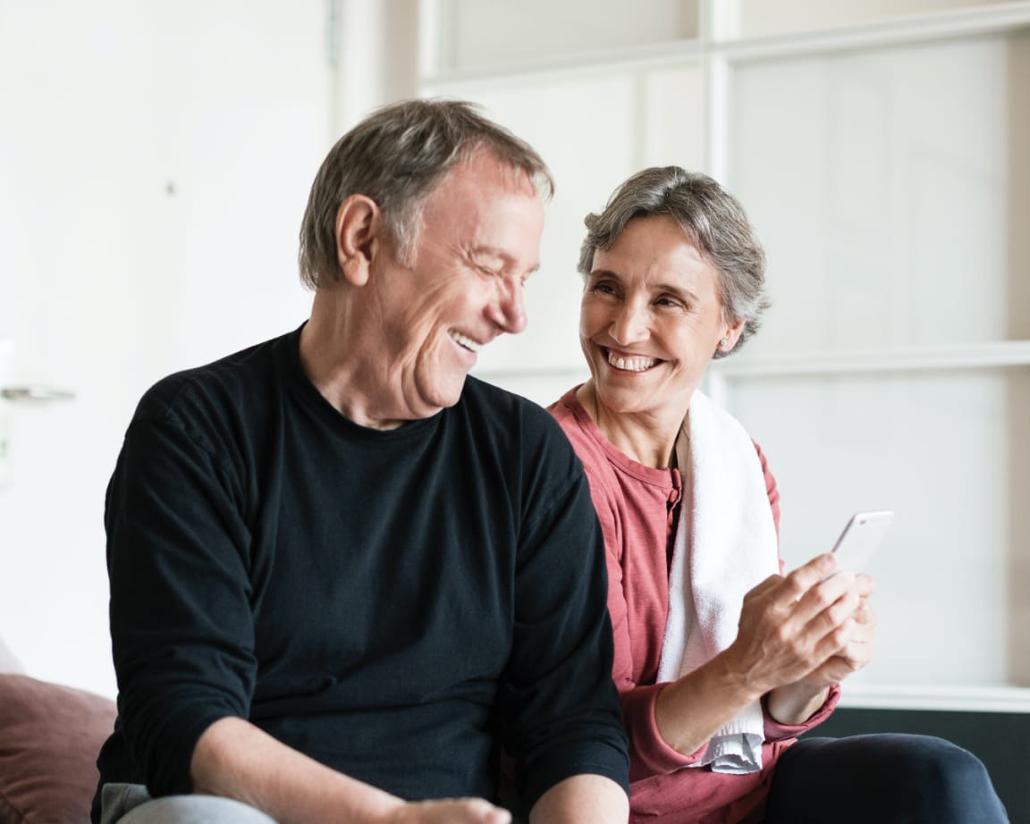 Couple smiling while looking at phone